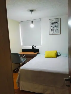 a bedroom with a bed with a yellow pillow on it at Adriana in Lima