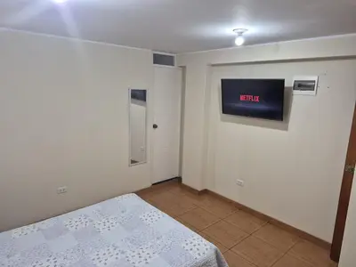a bedroom with a bed and a tv on the wall at Habitación privada 2do piso cerca a la Plaza Constitución in Huancayo