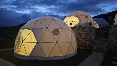 two dome tents sitting on the grass at night at Sky domos - laguna huaypo in Anta