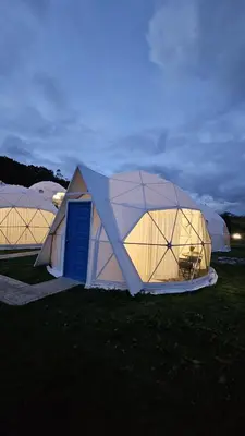 two large domes in a field at night at Sky domos - laguna huaypo in Anta