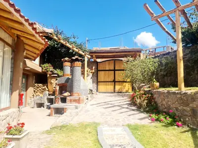 a house with two chimneys in a yard at Arins House in Cusco