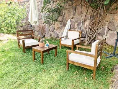 a group of chairs and tables on the grass at Arins House in Cusco