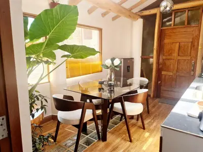 a dining room with a glass table and chairs at Arins House in Cusco