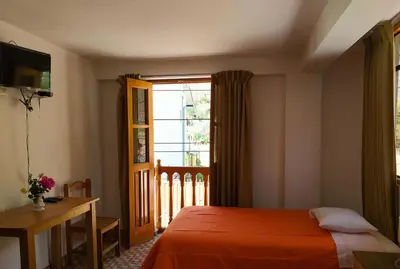 a bedroom with a bed and a window at Tambo de Ollantay Hotel in Ollantaytambo
