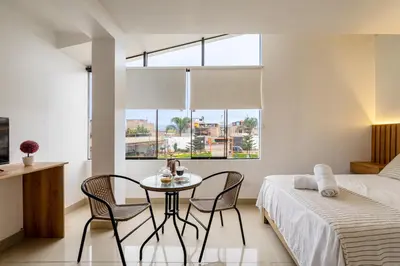 a bedroom with a table and chairs and a bed at Huaral House in Huaral