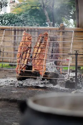 a grill with several pieces of meat on it at Huaral House in Huaral