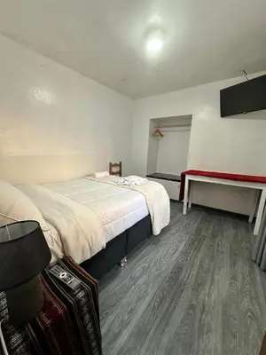 a bedroom with a large bed and a table at Habitaciones para Turistas en Zona Tranquila de Cusco in Cusco
