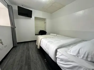 a small room with two beds and a television at Habitaciones para Turistas en Zona Tranquila de Cusco in Cusco