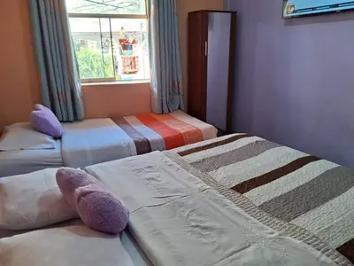 two beds in a room with a window at Hospedaje Don Pepe in Churín