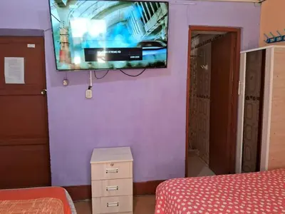 a room with a tv on a purple wall at Hospedaje Don Pepe in Churín