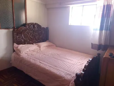 a bed in a bedroom with a window at El despertar del inka in Cusco