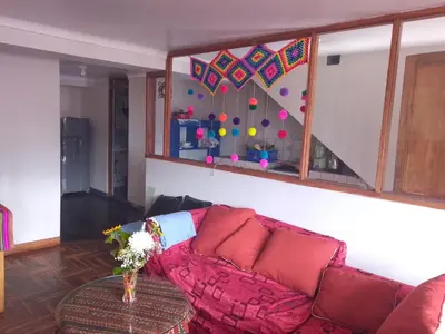 a living room with a couch and a staircase at El despertar del inka in Cusco