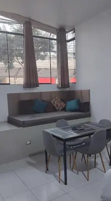 a living room with a couch and a table and chairs at Monoambiente Parque Naranjal B, a 20 minutos del Aeropuerto - Hasta 3 huéspedes in Lima