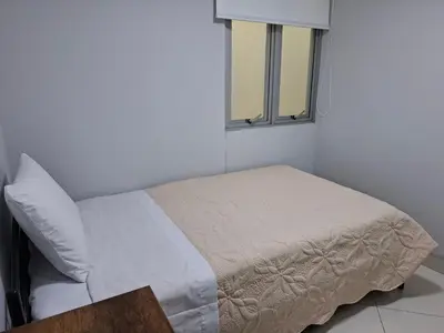 a white bed in a room with a window at Apartamento en condominio cerca a Plaza Norte in Lima