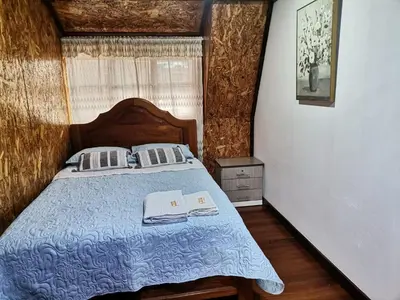 a bedroom with a bed with a blue comforter at La Cabaña del Tony in Villa Rica