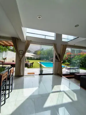 a large living room with a view of a pool at La Morada del Sol in Cieneguilla