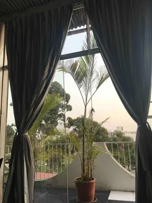 a room with a window with curtains and a plant at Miraflores Penthouse in Lima