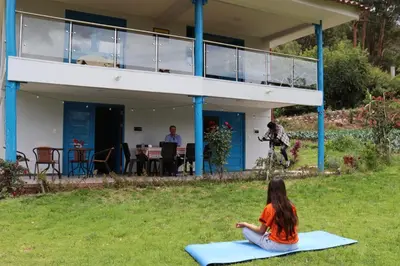 a woman sitting on a yoga mat in front of a house at Country house in nature in Sacred Valley in Huayllabamba
