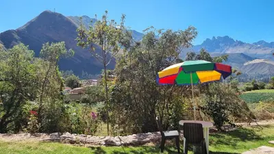 a colorful umbrella sitting on top of a field at Cottage in nature in Sacred Valley with mountain views in Huayllabamba