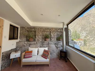 a living room with a stone wall at Chaqra in Urubamba
