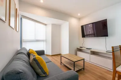 a living room with a couch and a tv at Elmora 2BR by Geko in Lima