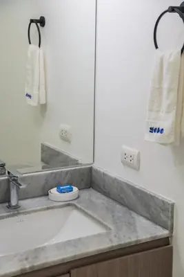 a bathroom with a sink and a mirror at Elmora 2BR by Geko in Lima