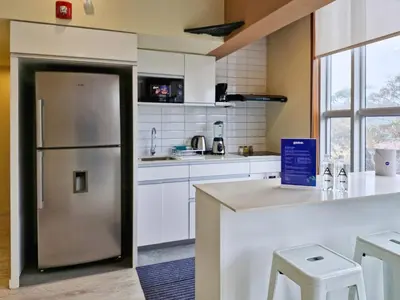a kitchen with a stainless steel refrigerator and white cabinets at Spacio 299 by Geko in Lima
