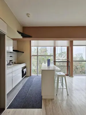 a kitchen with a counter and a table and some windows at Spacio 299 by Geko in Lima