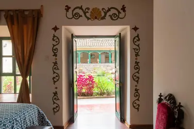a bedroom with a door leading to a garden at Hospedaje La Florida in Urubamba