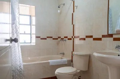 a bathroom with a toilet and a tub and a sink at Hospedaje La Florida in Urubamba