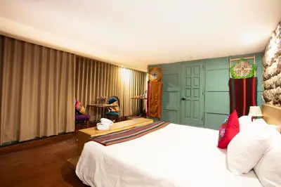 a bedroom with a white bed and a green wall at Casa Amará in Cusco