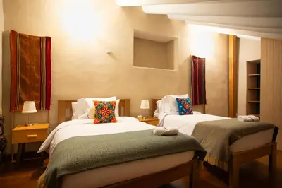 a hotel room with two beds with pillows at Casa Amará in Cusco
