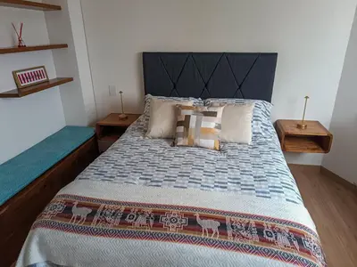 a bedroom with a large bed with a black headboard at Hermoso apartamento in Lima