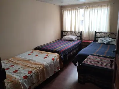 a bedroom with two beds and a window at TantaWasi in Cusco