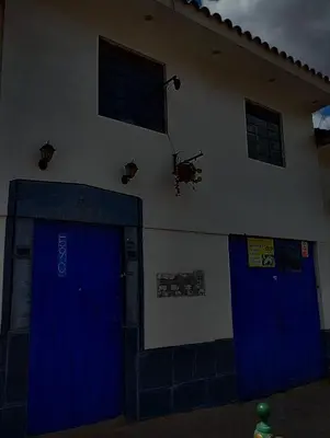 a building with blue doors and a helicopter on the wall at TantaWasi in Cusco