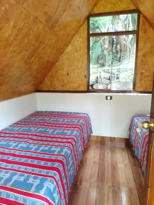 a bedroom with a bed and a window in a attic at Lucmabamba Cottage in Sahuayacu
