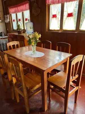 a wooden table with a vase of flowers on it at Schütze-Haus in Oxapampa