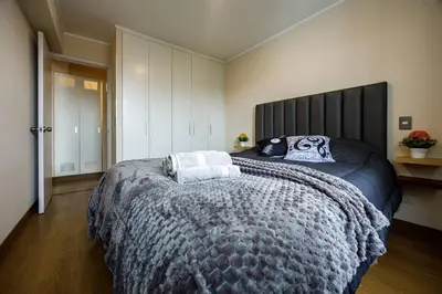 a bedroom with a large bed with a gray blanket at BSR Cozy Flat next to Av. Javier Prado w/ Pool&Gym in Lima