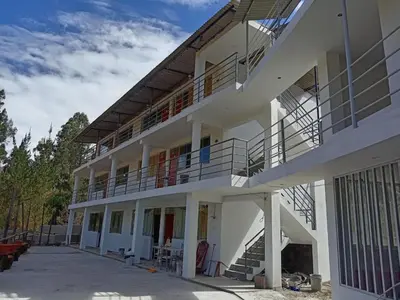 a large white building with a balcony and stairs at Hotel Campestre Corina