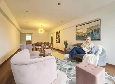 a woman sitting in a chair in a living room at E Malecon Larcomar Free Parking 3B 102 in Lima