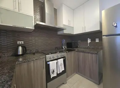 a kitchen with white cabinets and a stove top oven at E Malecon Larcomar Free Parking 3B 102 in Lima