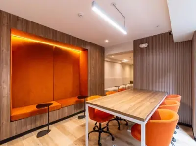 a conference room with a wooden table and orange chairs at Acogedor depa 2D 2B cerca a Kennedy y Larcomar in Lima