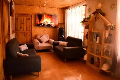 a living room with a couch and chairs and a fireplace at La posada del Minero - Oxapampa in Oxapampa