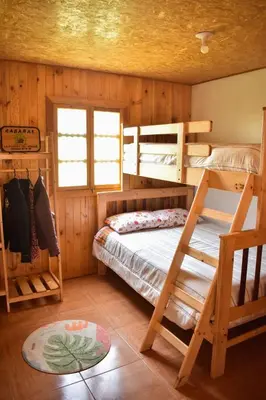 a bedroom with two bunk beds and a window at La posada del Minero - Oxapampa in Oxapampa