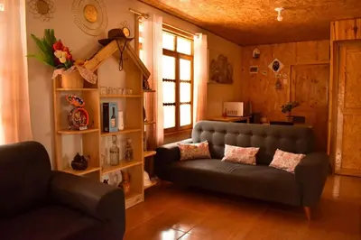 a living room with a couch and a chair at La posada del Minero - Oxapampa in Oxapampa