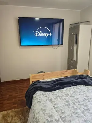 a bedroom with a bed and a television on the wall at In house ica in Ica