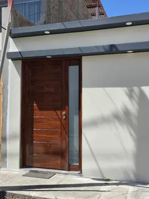 a wooden garage door with a black roof at Un house ica in Ica