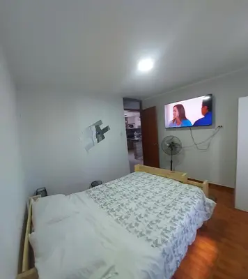 a bedroom with a bed and a tv on the wall at Un house ica in Ica