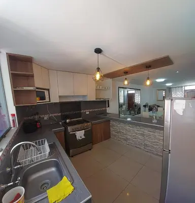 a kitchen with a sink and a stove top oven at Un house ica in Ica