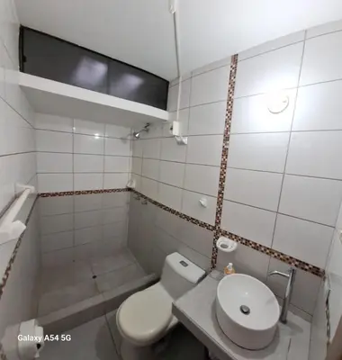 a white bathroom with a toilet and a sink at Un house ica in Ica